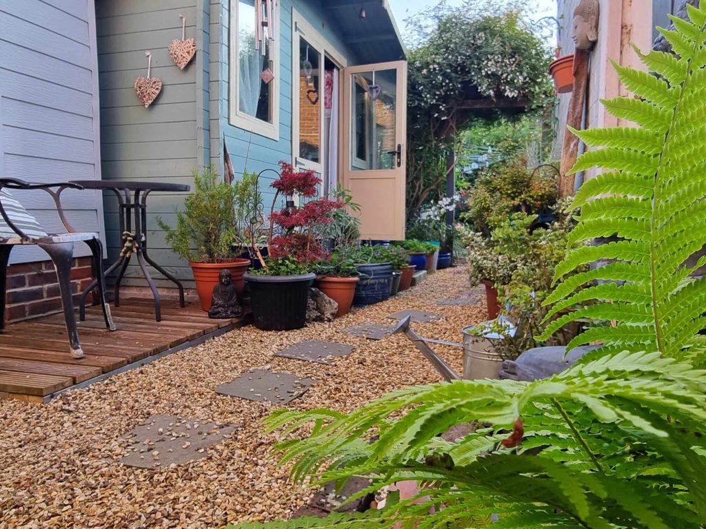 A tranquil gravel path leading through a peaceful garden, symbolising the journey of personal transformation.