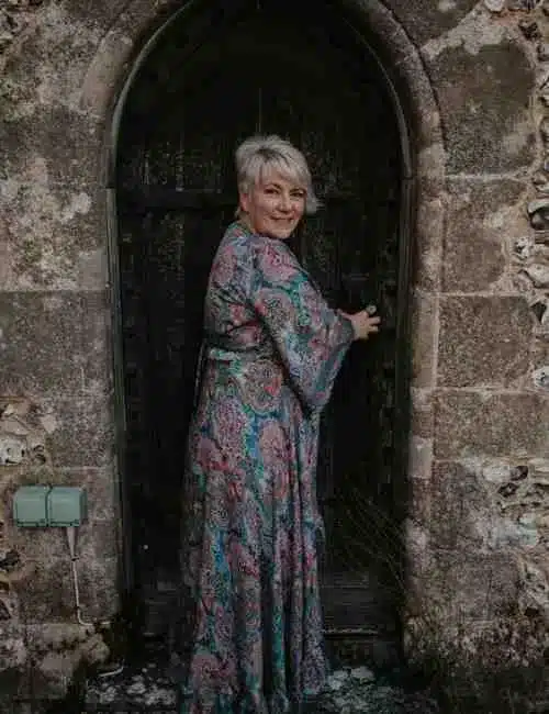 Tania Meacher standing before an ancient doorway, symbolising the threshold of healing, leadership, and ritual within the Ancestral Alchemy pathways.