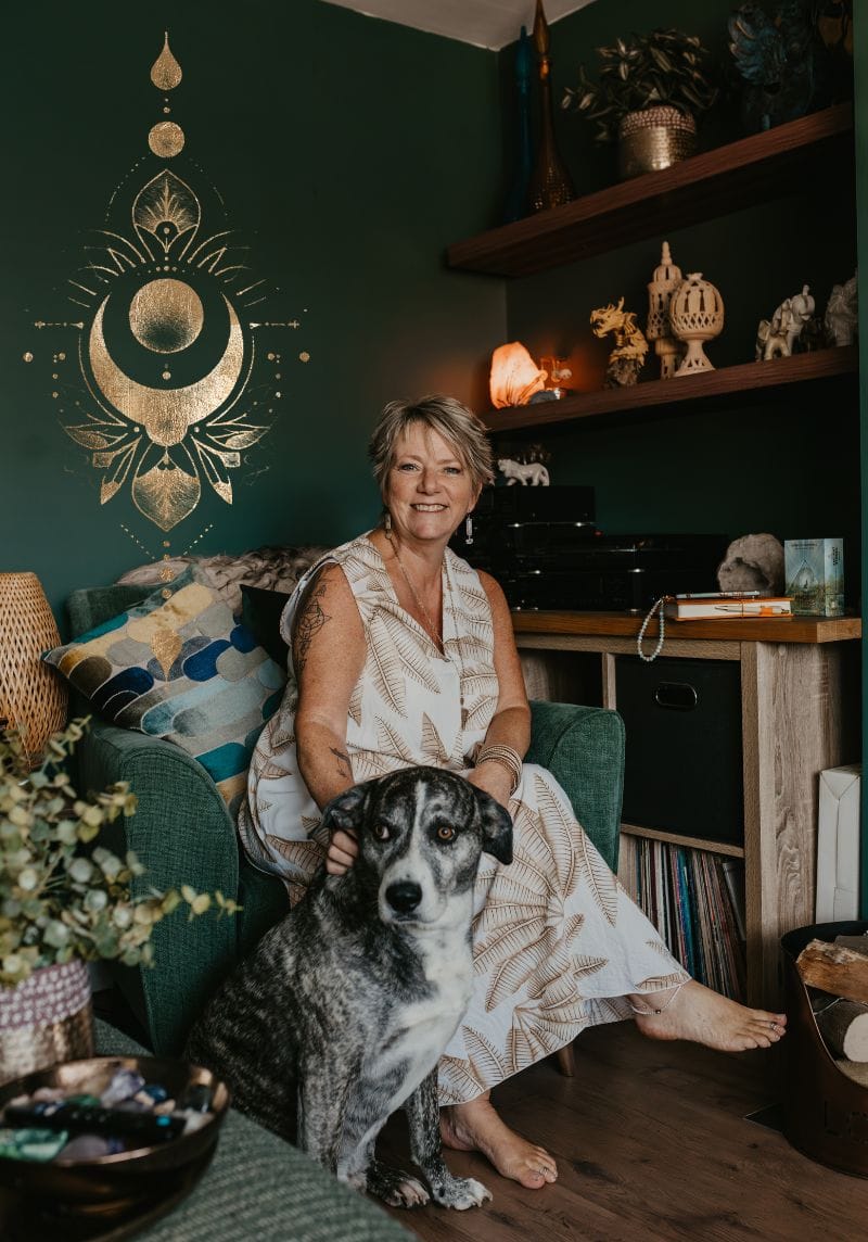 Creative Witch Designs - Spiritual Website Designer #2 (1) Tania Meacher sitting on a green sofa with her dog, Bodhi, in her home workspace.